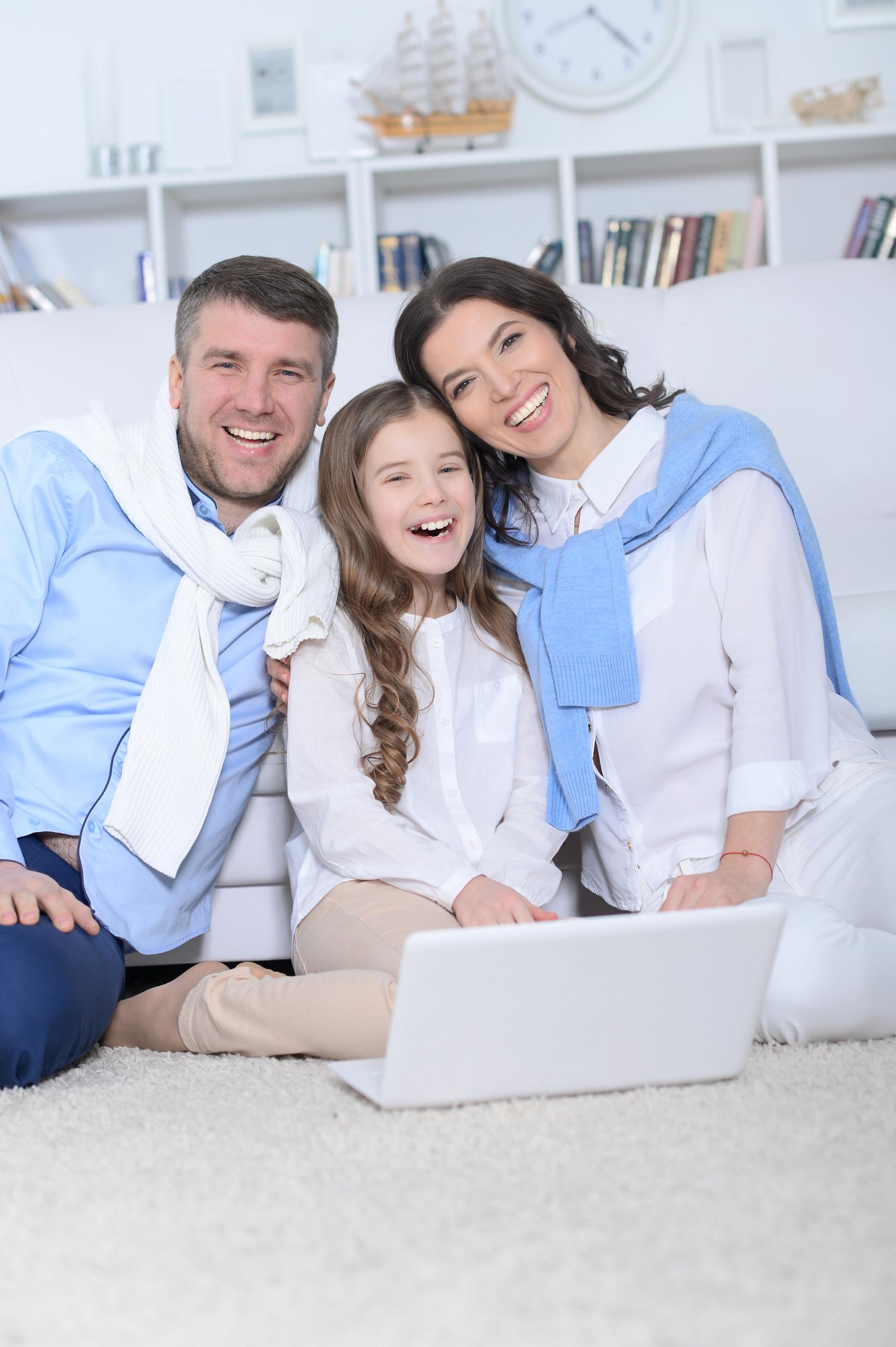 portrait-parents-daughter-using-laptop-room