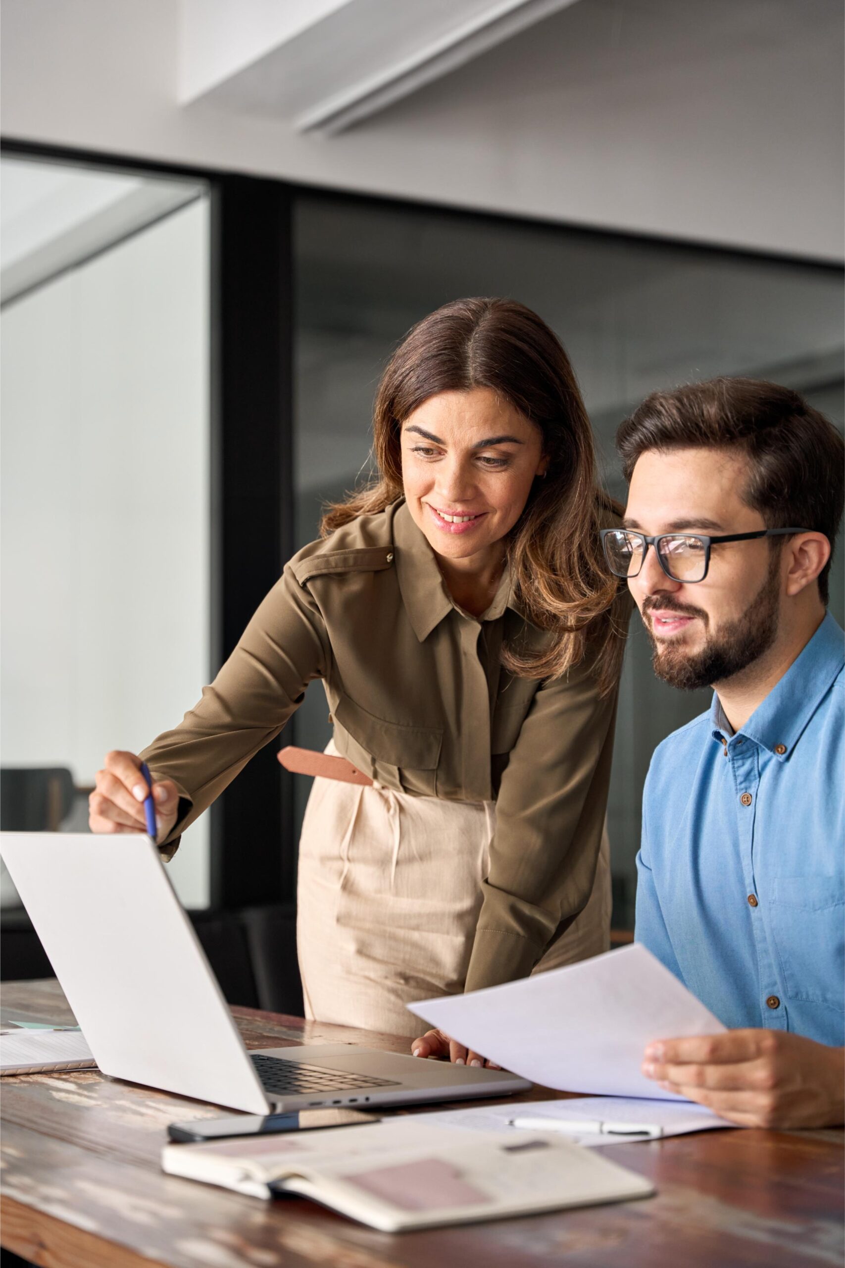 professional-woman-manager-explaining-corporate-software-helping-young-employee